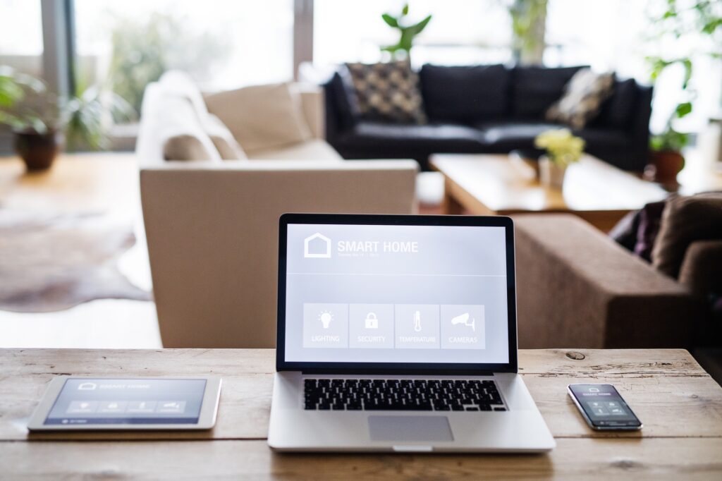 A laptop, tablet and telephone with smart home screen.