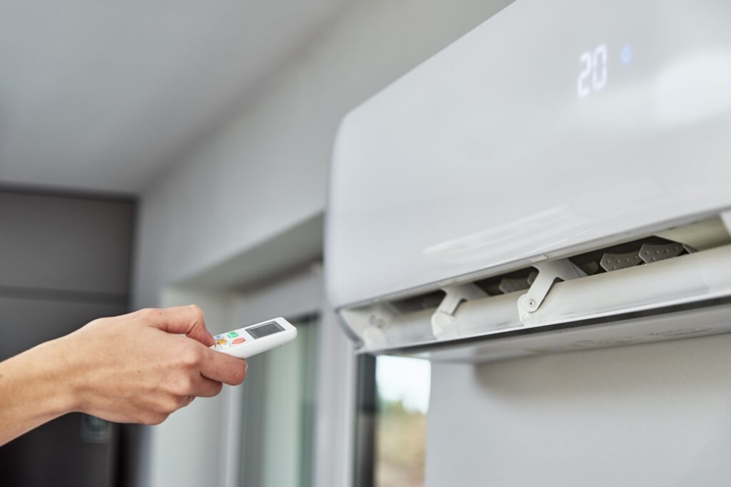 Hand adjusting temperature on air conditioner